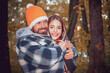 © Volodymyr - Happy smiling and hugging couple in warm knitted hat and scarf outdoor in autumn forest. Cozy mood and autumn inspiration concept. Couple in Autumn fall mood. Man and woman near Autumn fall leaves.