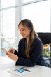© PIC SNIPE - Businesswoman sitting at desk on couch in workplace or at home working on laptop and analyzing data on charts and graphs and writing on papers to make business plan and strategies for company.