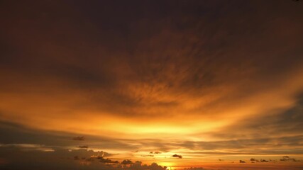 Wall Mural - a sunset timelapse showcasing the vibrant interplay of warm orange and golden hues illuminating the 