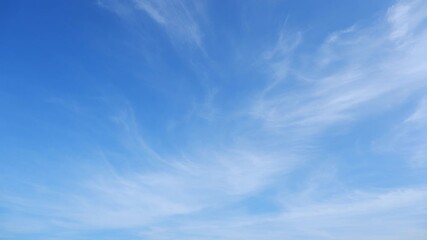 Wall Mural - A timelapse reveals the sky’s serene flow, as wispy clouds gently drift across a brilliant blue canvas, highlighting nature’s calm, ever-changing beauty and the seamless passage of time. Time-lapse.
