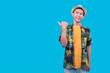 © Gatot - Happy Young Asian Man Smiling And Pointing His Thumb To The Empty Space On A Blue Background