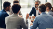 © Tomo - Diverse businesspeople discussing around a round table in a conference room