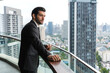 © Jack Tamrong - Good looking Caucasian business man standing at high rise office balcony