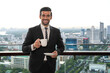 © Jack Tamrong - Handsome Caucasian businessman holding coffee standing at high rise office balcony
