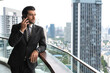© Jack Tamrong - Good looking Caucasian business man standing and talking on phone at high rise office balcony