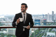 © Jack Tamrong - Good looking Caucasian business man standing at high rise office balcony drinking cup of coffee