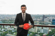 © Jack Tamrong - Good looking Indian project manager holding safety helmet  standing at high rise office balcony