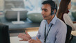 © Leny Studio - Focused Indian male tech support agent provides helpful customer service from modern call center. Professional operator on call talking to client with headset