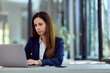 © bnenin - Focused Businesswoman Working on Laptop in Modern Office Environment