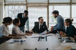 © qunica.com - A diverse group of business people engaged in a collaborative meeting in a modern office. The image highlights teamwork and strategy planning with dynamic interaction among colleagues.