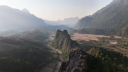 Wall Mural - sharp limestone cliffs of nam xay tower above the rural valley of vang vieng, laos, with winding roa