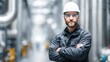 © ttonaorh - A male industrial engineer wearing a white helmet and safety glasses stands in front of an oil production plant.