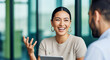© Kamran - A joyful businesswoman enthusiastically talking with a colleague in a modern office. Perfect for concepts of dynamic communication and positive engagement