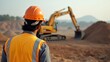 © Avinash - Site engineer in a safety helmet overseeing an excavator working on a construction development project.