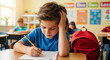 © Jed - Young boy focused on math worksheet at his desk in a lively elementary classroom, backpack on chair, cheerful posters in background