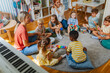 © lordn - Preschool teacher leading a diverse group of children in a fun music activity, playing instruments together in a circle.