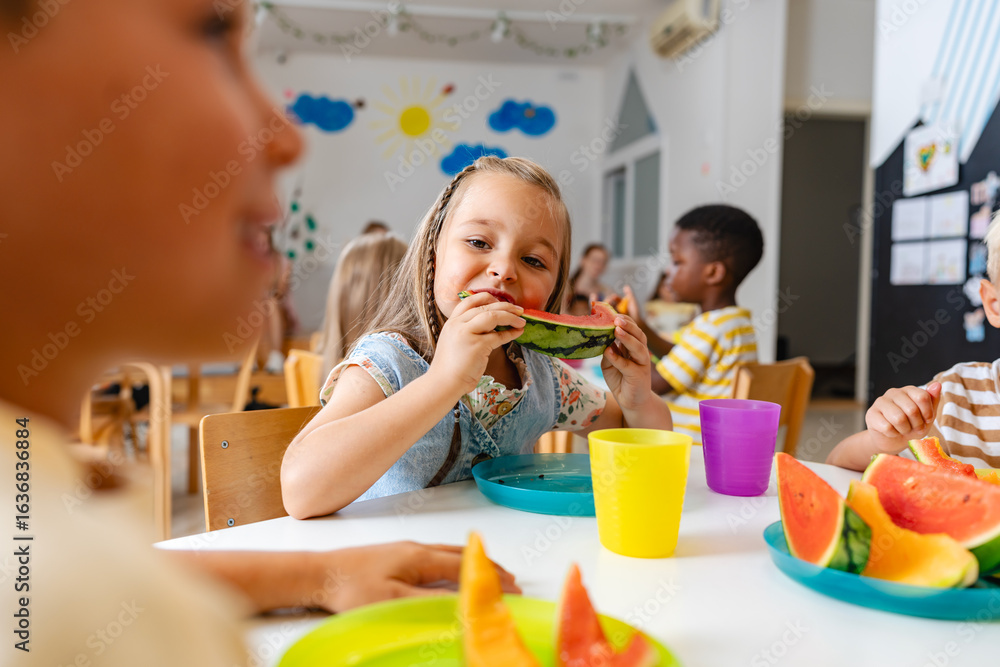 Preschool children enjoying fresh watermelon slices during snack time ...