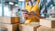 © Johannes - female small business owner using mobile app on smartphone checking parcel box warehouse worker seller holding phone scanning retail dropshipping package postal parcel bar code on cell technology no