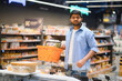 © Serhii - Indian man shopping for groceries in supermarket with basket