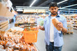 © Serhii - Hindu man choosing bread in supermarket bakery section