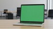 © TheseusStock - Front view of a laptop with a blank white screen on a wooden table in an office, with a blurred background.