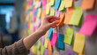 © happy - Sticky Note Symphony: A focused individual meticulously arranges a vibrant array of sticky notes on a collaborative brainstorming wall, each note a colorful fragment of ideas and strategies.