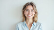 © abu - Portrait of smiling white woman, light brown hair, wearing light blue shirt on white background.