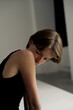© ULYANA_1995 - Young woman in black tank top looking down pensively in dramatic studio lighting