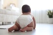 © New Africa - Cute little baby crawling on floor at home, back view