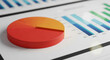 © Mirivox - Close-up of 3D pie chart with orange and red sections, resting on a document showing bar graphs, illustrating data analysis and business presentation