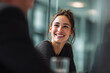 © Arya - Young woman with dark hair smiling during a business meeting with colleagues happy laughing