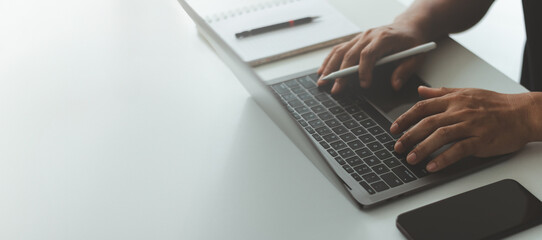 Hands typing on a laptop keyboard, with a smartphone on the desk, remote work, freelance lifestyle, digital communication, online business, modern technology, marketing, web development, education.