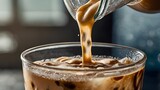Pouring a rich stream of freshly brewed coffee into a glass filled with ice cubes, creating a delicious and energizing iced latte. A concept of morning refreshment and caffeine boost.