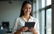 © gu - Successful smiling latin hispanic young woman using pad computer for business app. Busy executive CEO businesswoman professional holding digital tablet pc device for work in modern office workplace.