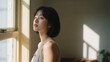 © Galadriel Gesso - Thoughtful Asian Woman by Window Serene Sunlight Shadows Peaceful Calm