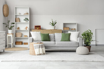 Poster - interior of stylish living room with grey sofa, wicker coffee table and shelving unit