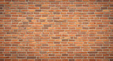 A detailed close up view of a weathered and textured red brick wall with visible mortar lines creating a classic architectural background