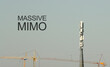 © Andrii - 5G Massive MIMO Telecommunication tower. Cell Site Digital Cellular Telecommunication Tower Network Antenna and cranes on clear sky background