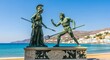 © syihab - Bronze Statues of Athena and Poseidon, Greek Mythology, Coastal Scene.