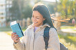 © luismolinero - Young woman at outdoors holding a passport with happy expression