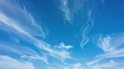 Wall Mural - time-lapse view of white clouds gliding through multiple layers in a sunny blue sky.