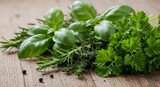 Close-up of fresh basil, rosemary, thyme, and parsley herbs with scattered peppercorns on a wooden surface.
