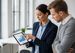 © Parvin - Businesswoman pointing at tablet with graphs during meeting with businessman in office analyzing data for financial report and strategy