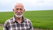 © bestimagestock - A man stands confidently in front of a vast, open field, surrounded by tall grass swaying gently in the breeze under a clear blue sky.