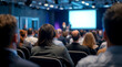 © Ada - Business event in conference hall. perspective of an attendee at a conference or lecture. The image shows a large, diverse audience seated in rows, with the backs of their heads and shoulders