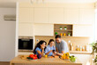 © BGStock72 - Friends enjoying a joyful time in a modern kitchen with fresh ingredients