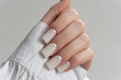 © Sviatlana Barysevich - Glossy white manicure – elegant long nails with smooth polish, minimal chic nail art design. The thumb and fingertips are slightly rounded, showcasing an elegant style.