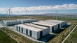 © Domingo - Modern renewable energy storage facility with massive battery systems surrounded by wind turbines under dramatic cloudy sky in sustainable power generation landscape