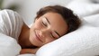 © 沈军 贡 - A woman is resting peacefully in bed with closed eyes, enjoying a comfortable and serene sleep on a white pillow.
