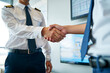 © Sayed GraphicsBD - Two pilots in uniform shaking hands in agreement